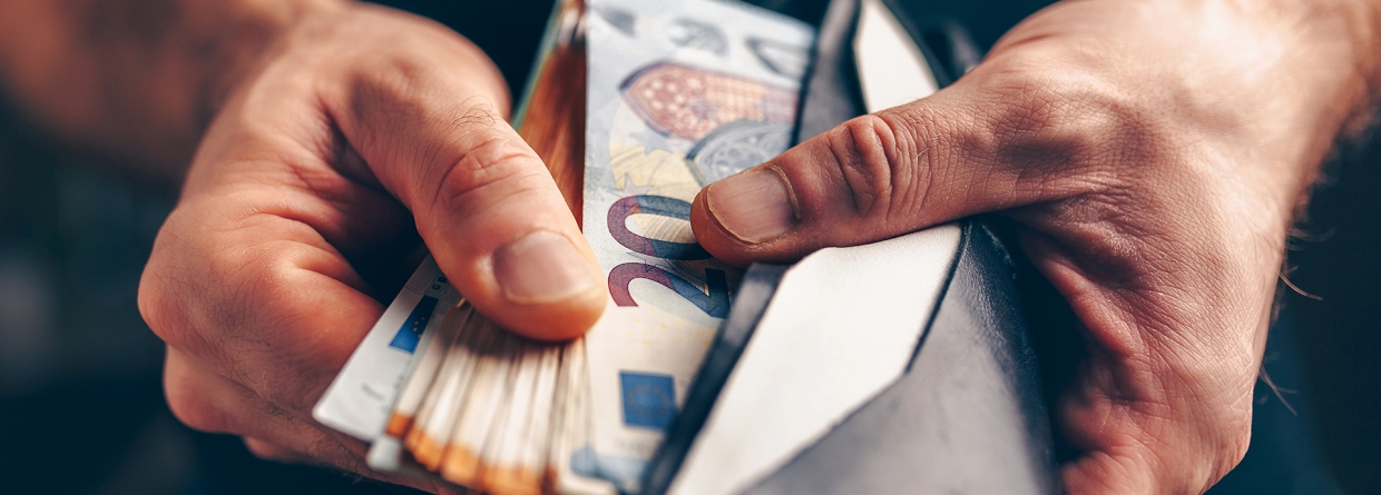 Man met een portemonnee in zijn hand gevuld met geld 