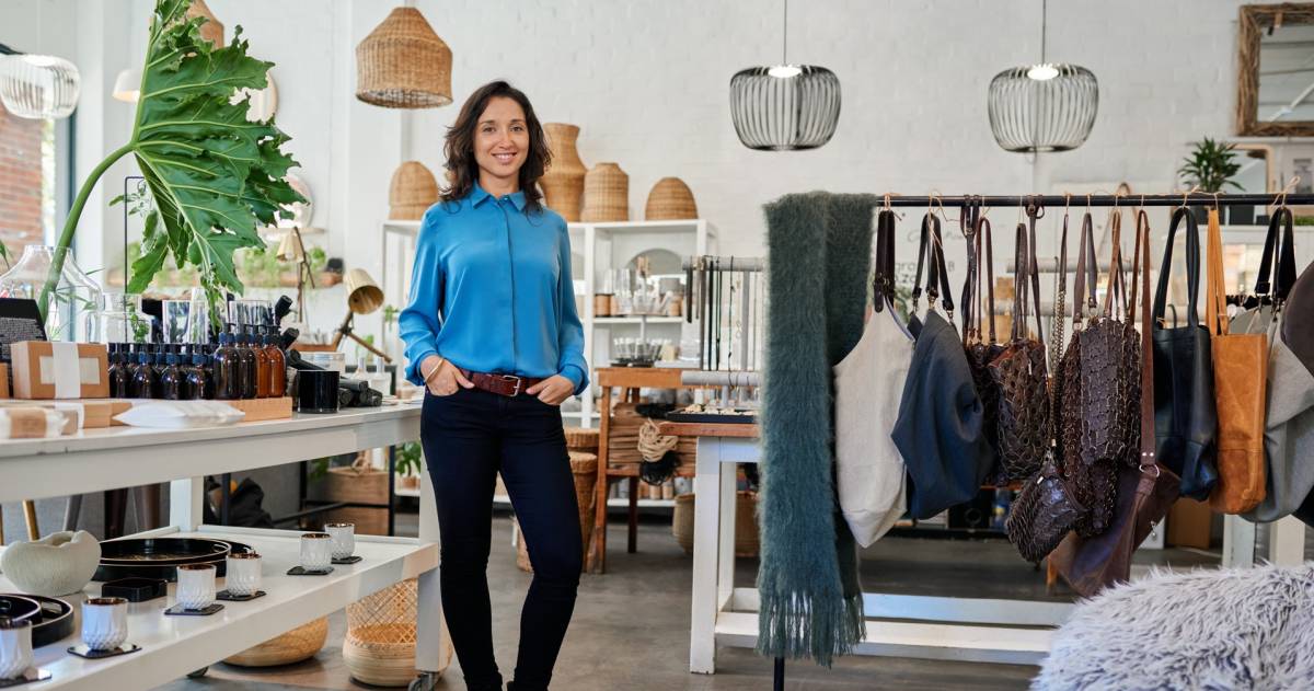 Vrolijke jonge ondernemer in haar eigen trendy winkel